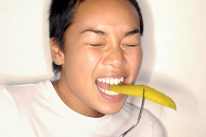 gusto amaro, donna che fa una smorfia mentre addenta un alimento