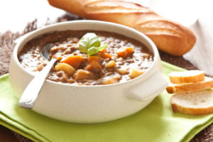 Ciotola di minestrone o zuppa con cucchiaio; concept: minestroni pronti