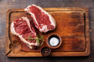 Raw fresh meat Ribeye Steak and seasoning on dark background