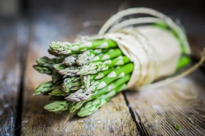 Mazzo di asparagi avvolto da carta e spago su un tavolo