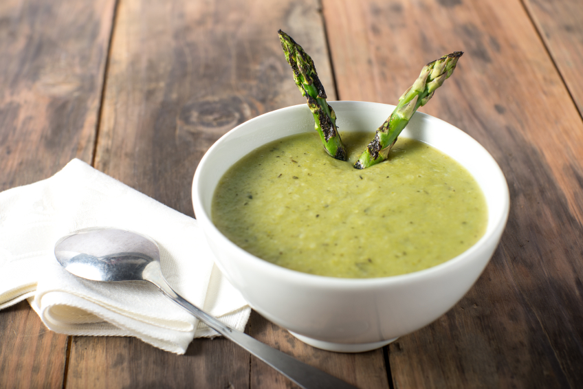 Crema di asparagi con punte di asparagi, cucchiaio e tovagliolo