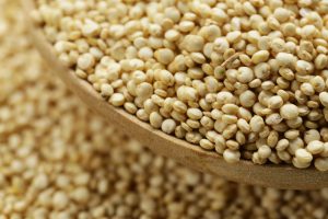 Grani di quinoa in cucchiaio di legno