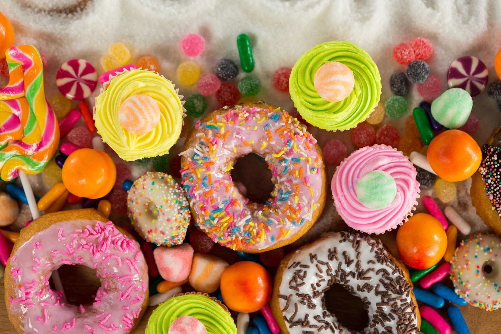 Donuts, cupcake dolci e caramelle multicolore; concept: zucchero cibo