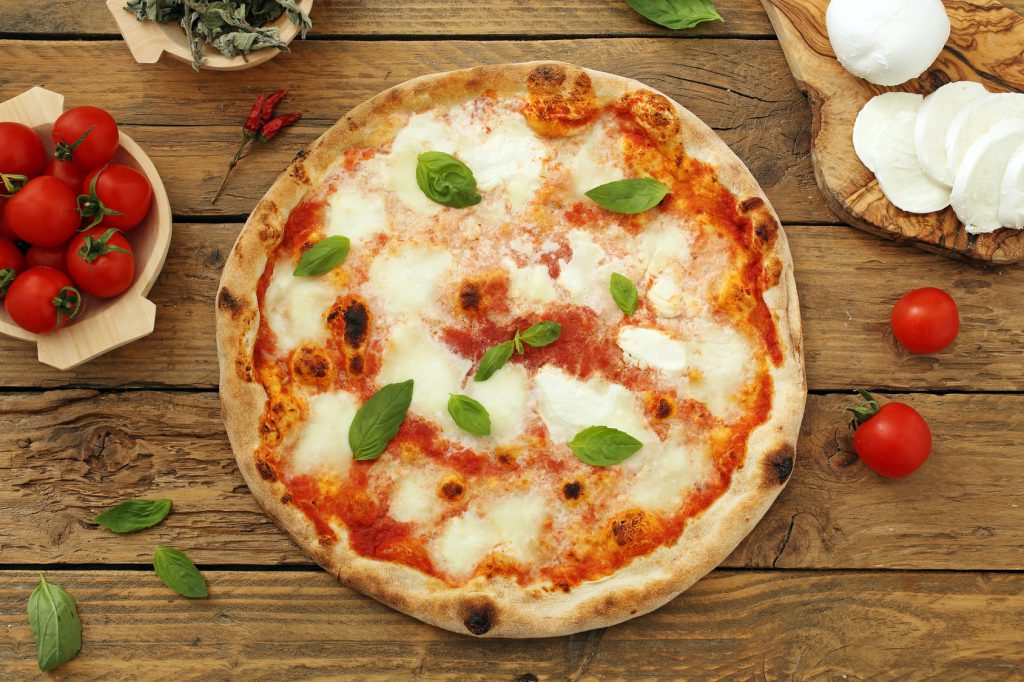 pizza margherita su sfondo rustico mozzarella