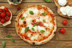 pizza margherita su sfondo rustico mozzarella