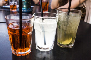 Tre cocktail sul bancone di un bar; concept: apertiivo