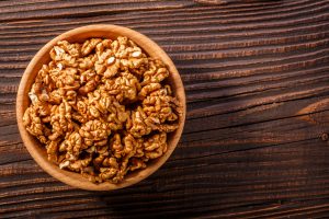 Noci sgusciate in una ciotola su un tavolo di legno