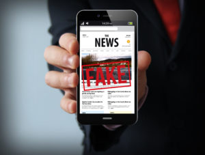 covid, fake news businessman smartphone coronavirus