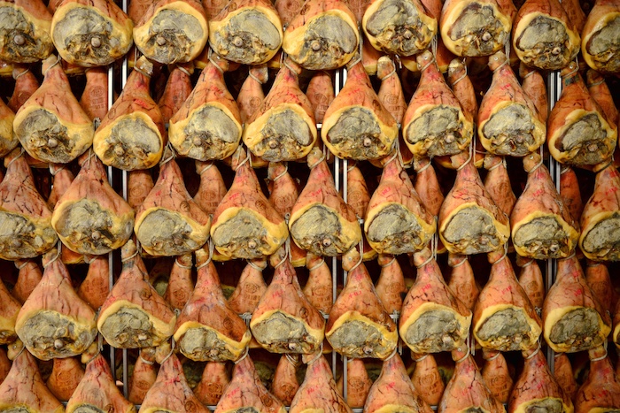 Cosce di maiale appese a stagionare per la produzione di prosciutto di Parma o San Daniele; concept: prosciuttopoli