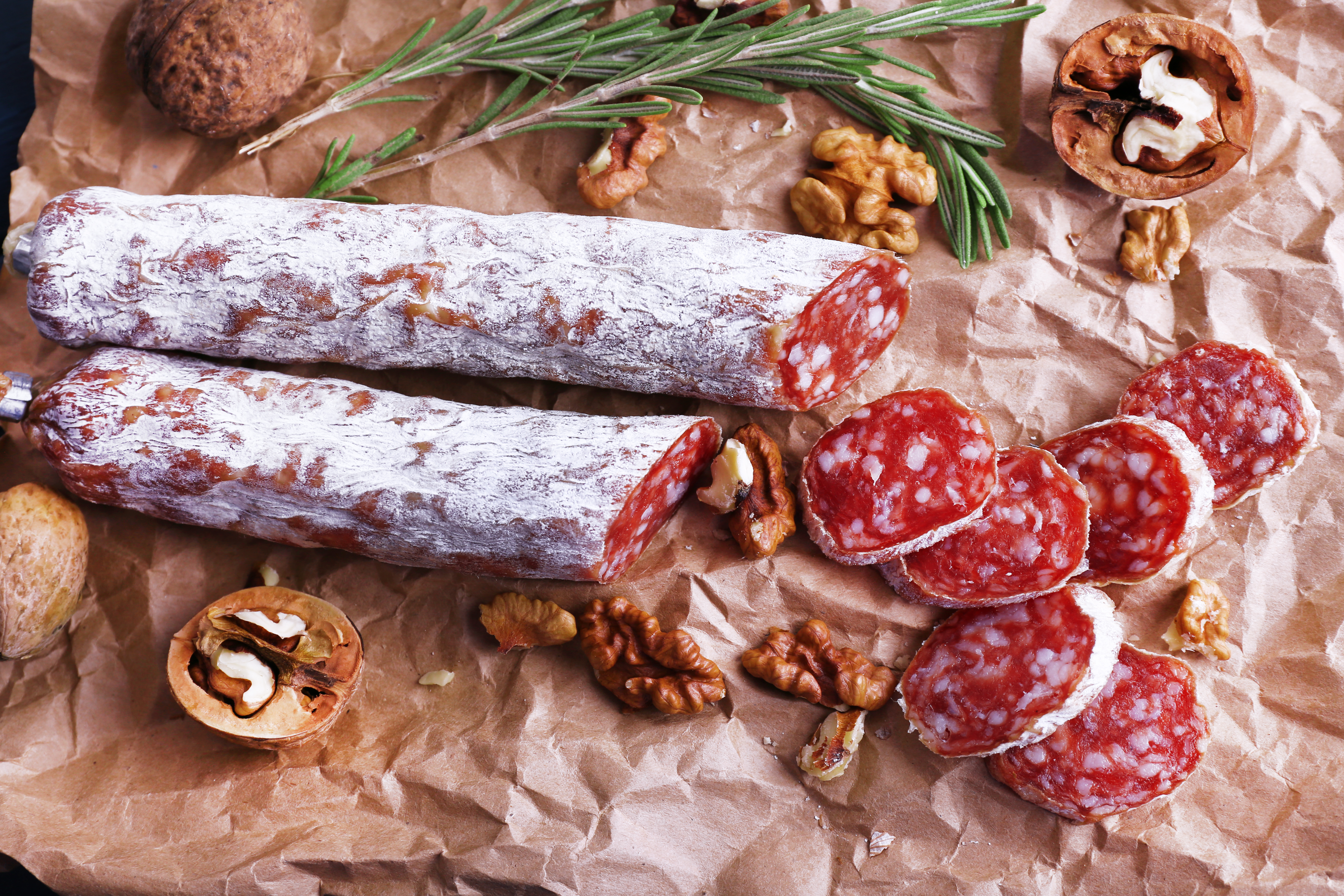 French salami and walnuts on craft paper background