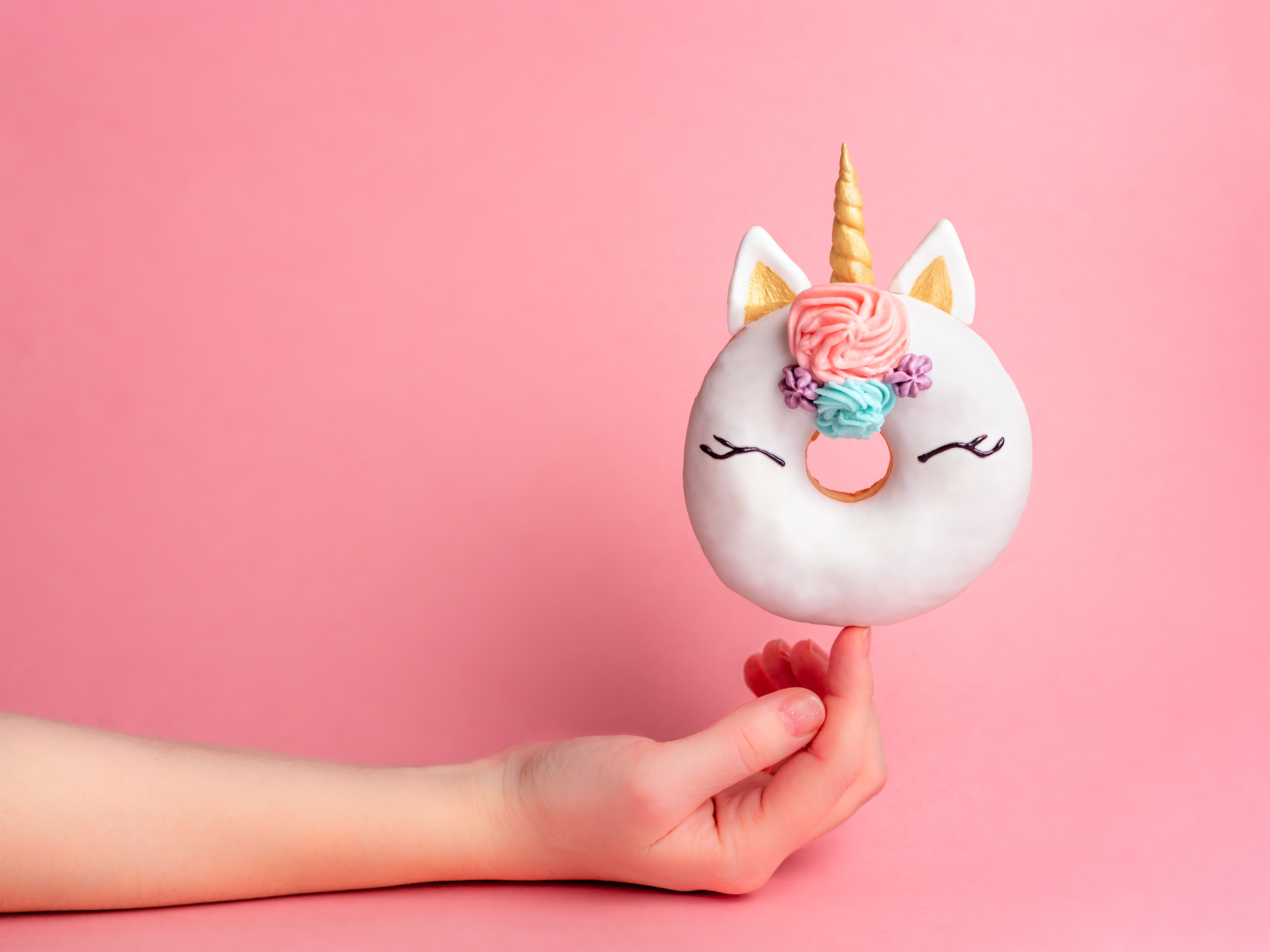 Donut o ciambella a forma di unicorno decorata con glassa; concept: biossido di titanio