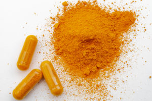 Capsule di integratori e polvere di curcuma o curcumina