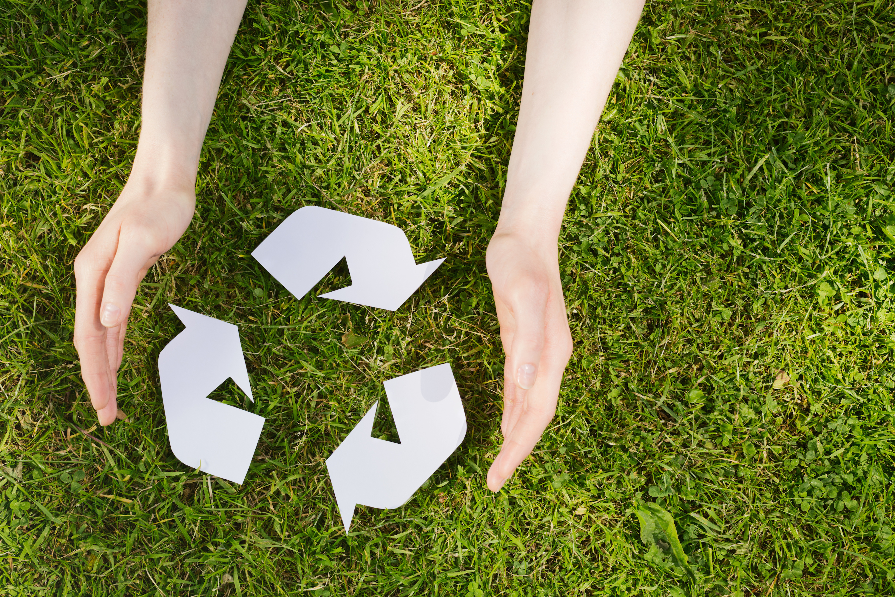 Hands with Recycling Sign on Grass