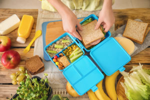 Mother preparing lunch for schoolchild at table
