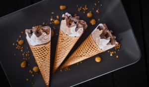 Tre coni gelato con panna, cioccolato e nocciola