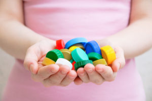 The girl is holding a plastic cap. Close-up.
