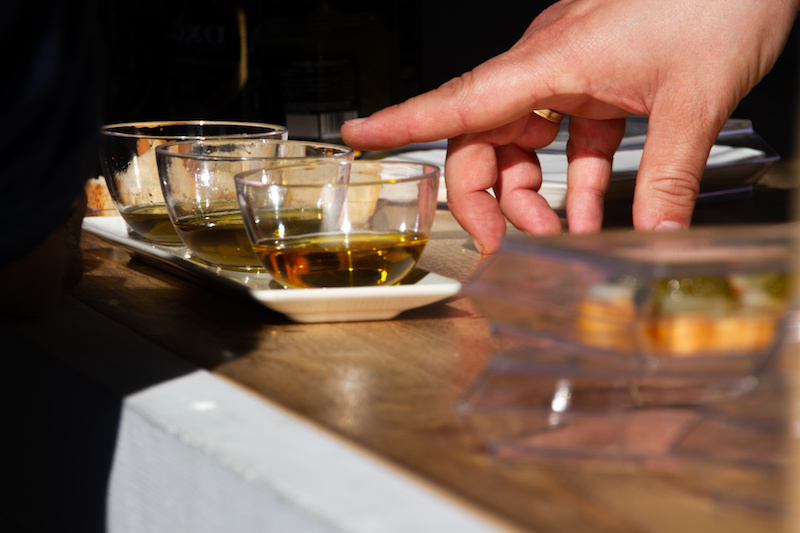 Dito appoggiato su ciotolina di olio extravergine di oliva; concept assaggiatore, panel test