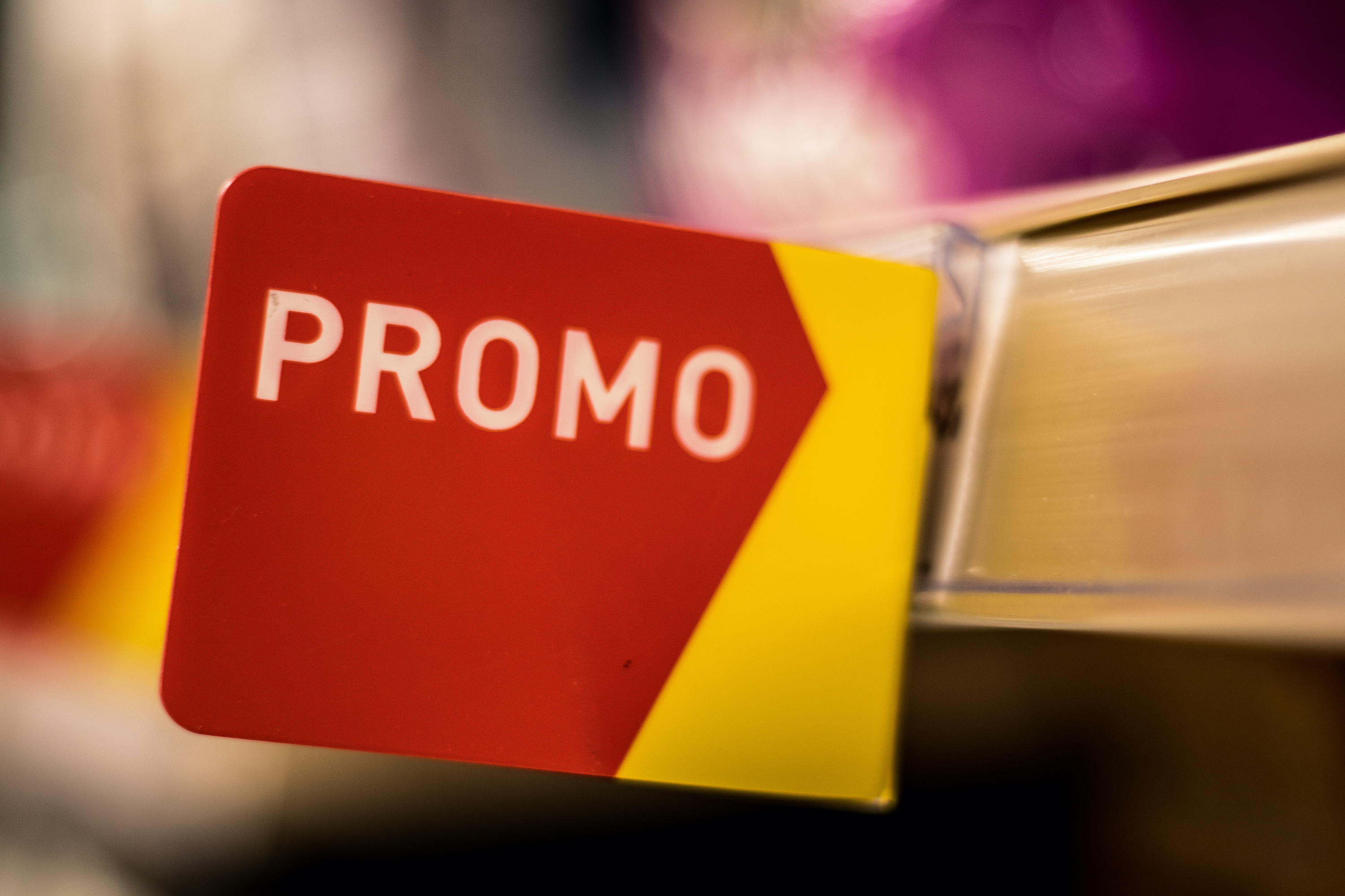 Un cartello promozionale rosso e giallo sullo scaffale di un supermercato; concept: offerte, promozioni, supermercati, prezzi