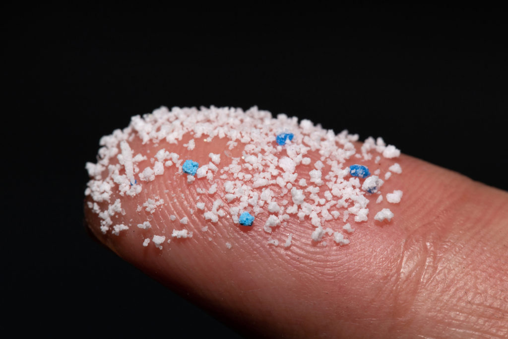 Micro plastic.Small Plastic pellets on the finger. microplastiche frammenti plastica