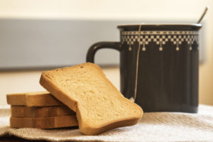 Fette biscottate impilate davanti a una tazza di tè, tisana o infuso