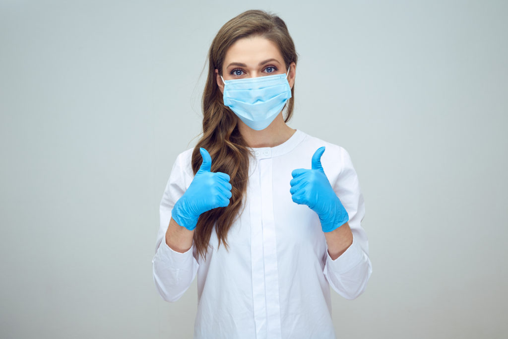 woman doctor wearing medical mask doing thumb up.