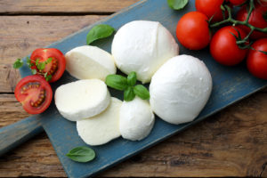 mozzarella prodotto tipico Italiano derivato dal latte con pomodori e basilico