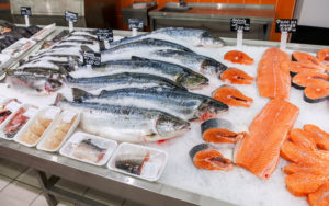 Salmoni interi, a tranci e filetti sul banco di una pescheria