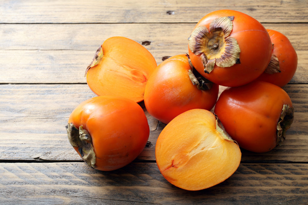 frutta di stagione cachi freschi su tavolo rustico