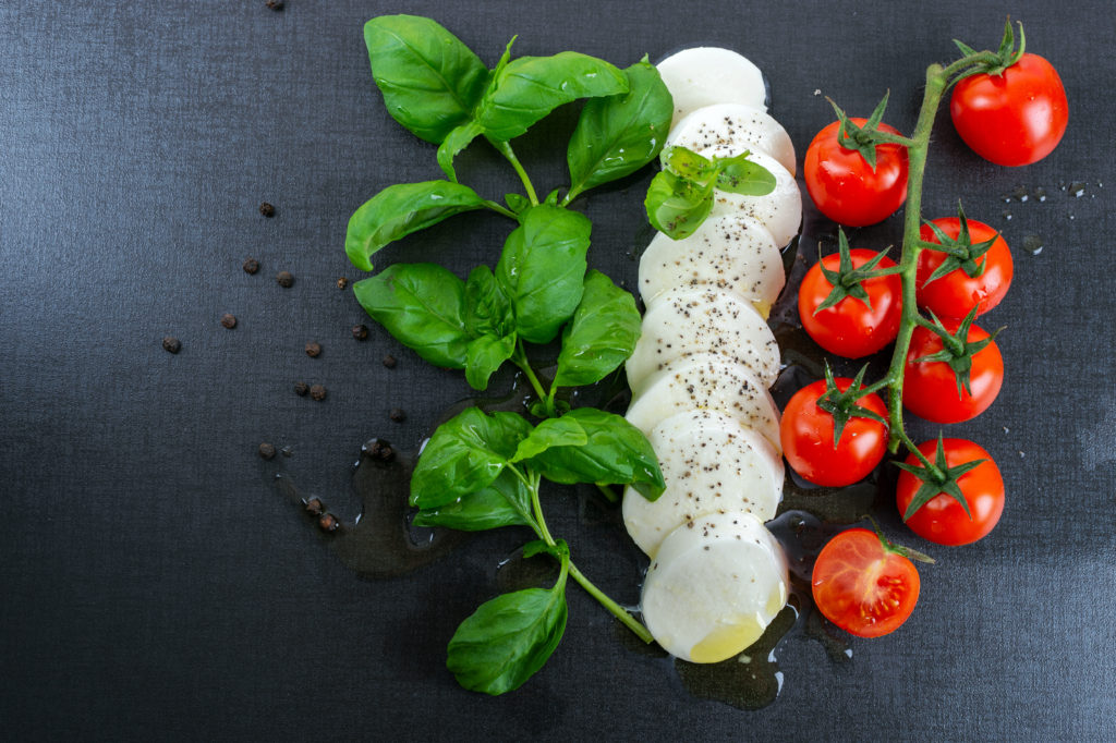 basilico, mozzarella a pomodoro su sfondo nero