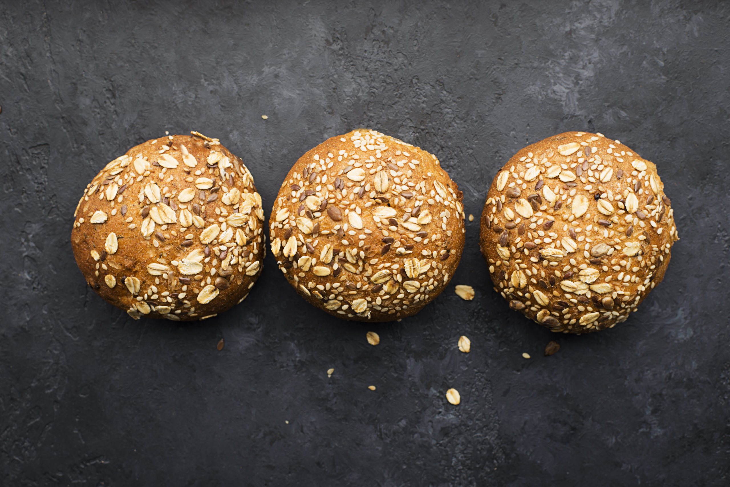 Wholegrain burger buns on dark background. Top view, space.