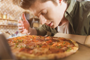 lungo covid, persona che annusa una pizza