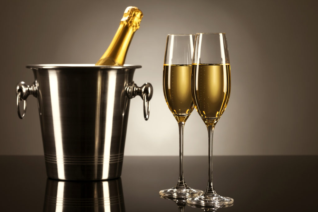 Due calici di champagne o prosecco con un a bottiglia in un secchiello