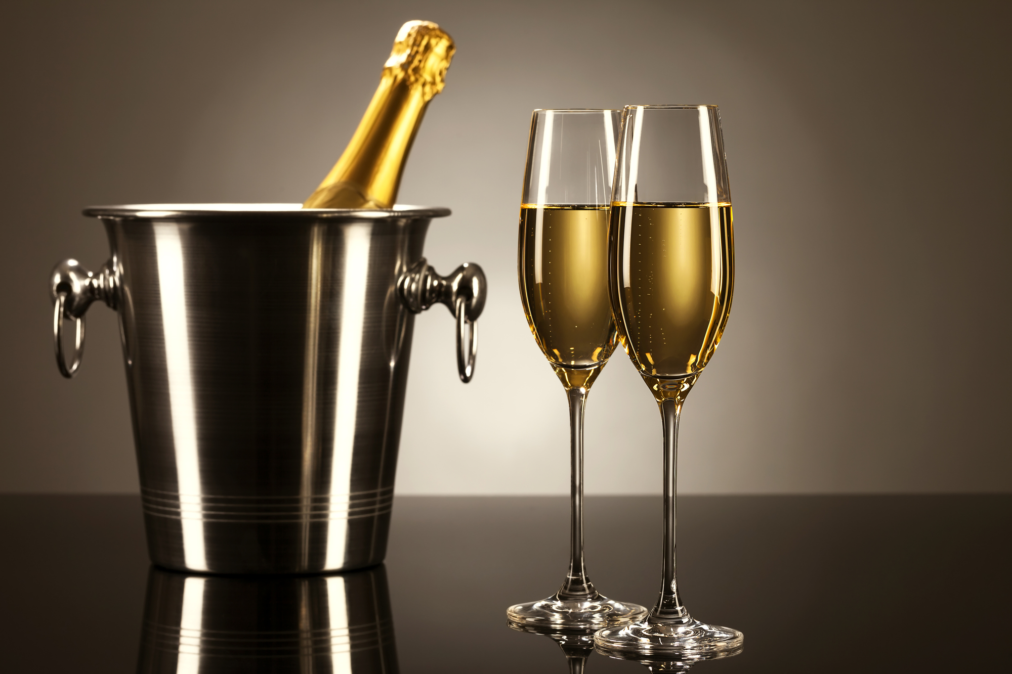 Due calici di champagne o prosecco con un a bottiglia in un secchiello
