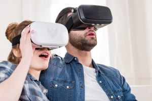 Una donna e un uomo indossano un visore per la realtà virtuale; metaverso