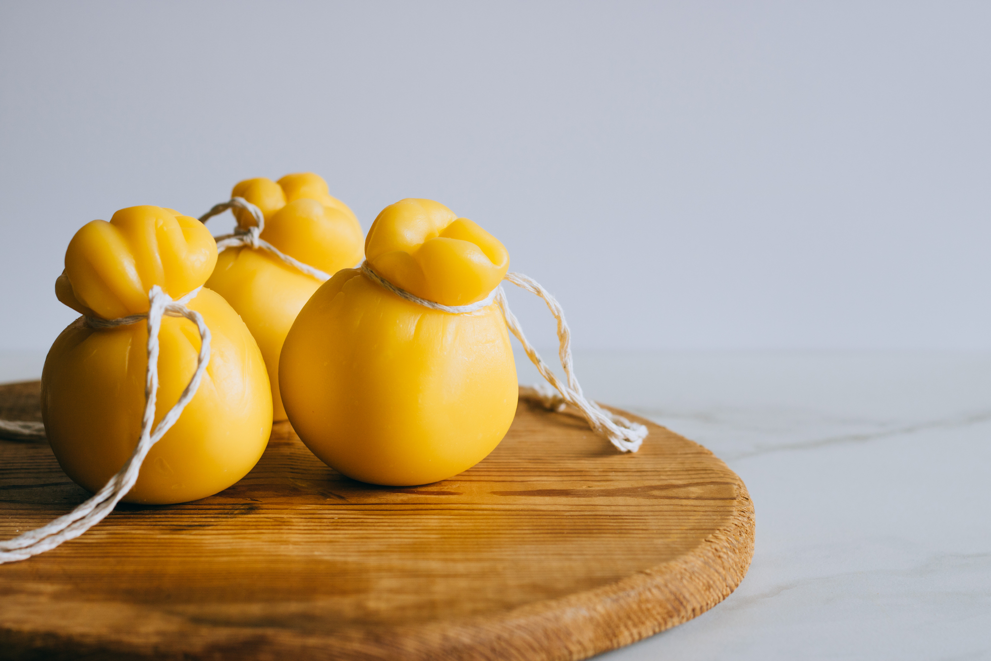 Scamorza su tavola di legno, sfondo marmo