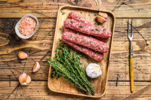Salsicce fatte in casa su un vassoio con aglio e rosmarino