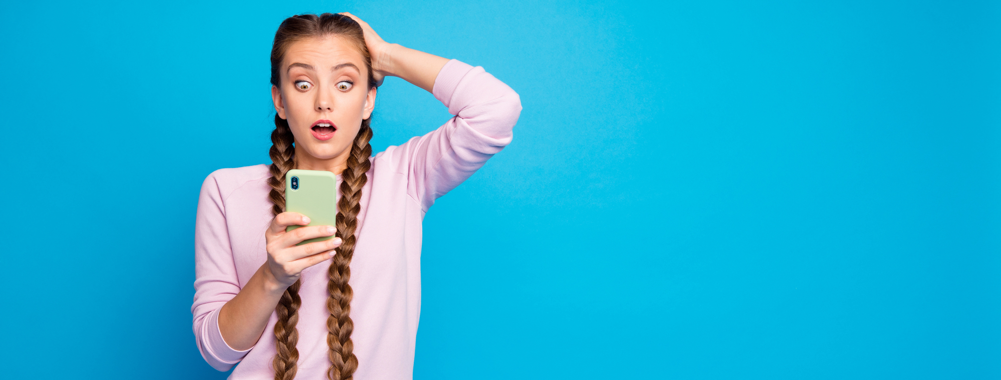 Ritratto di ragazza frustrata impressionata con lunghe trecce ottenere social media blog post commento guardare cellulare smartphone