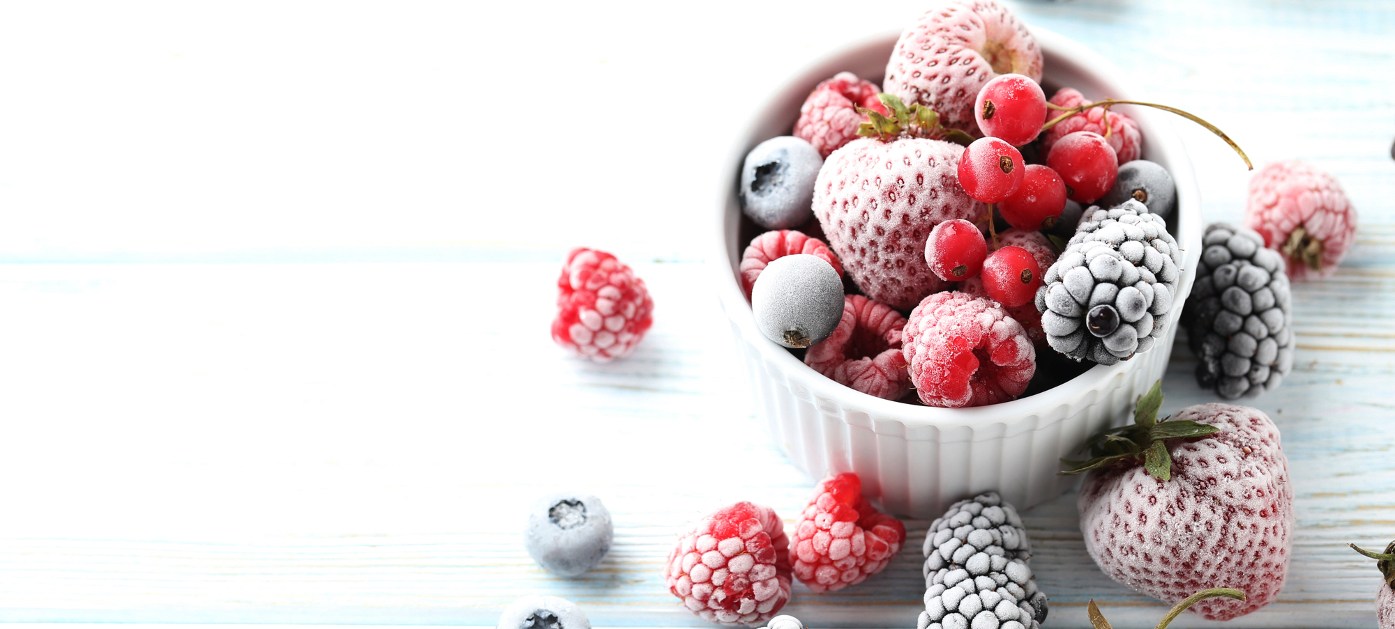 Frutti di bosco congelati su un tavolo di legno bianco