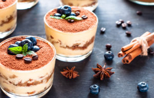Tiramisù in bicchiere di vetro con mirtilli, anice stellato e cannella