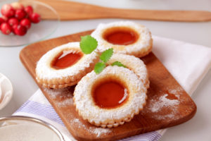 Biscotti ripieni di marmellata su un vassoio di legno