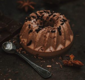 Dessert italiano. Panna cotta al cioccolato fondente, con pezzo di cioccolato e zuccherini al cioccolato su sfondo scuro anice stellato cacao budino dolci zuccchero