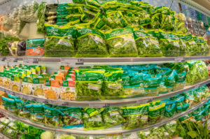 Banco frigo di un supermercato con insalate in busta