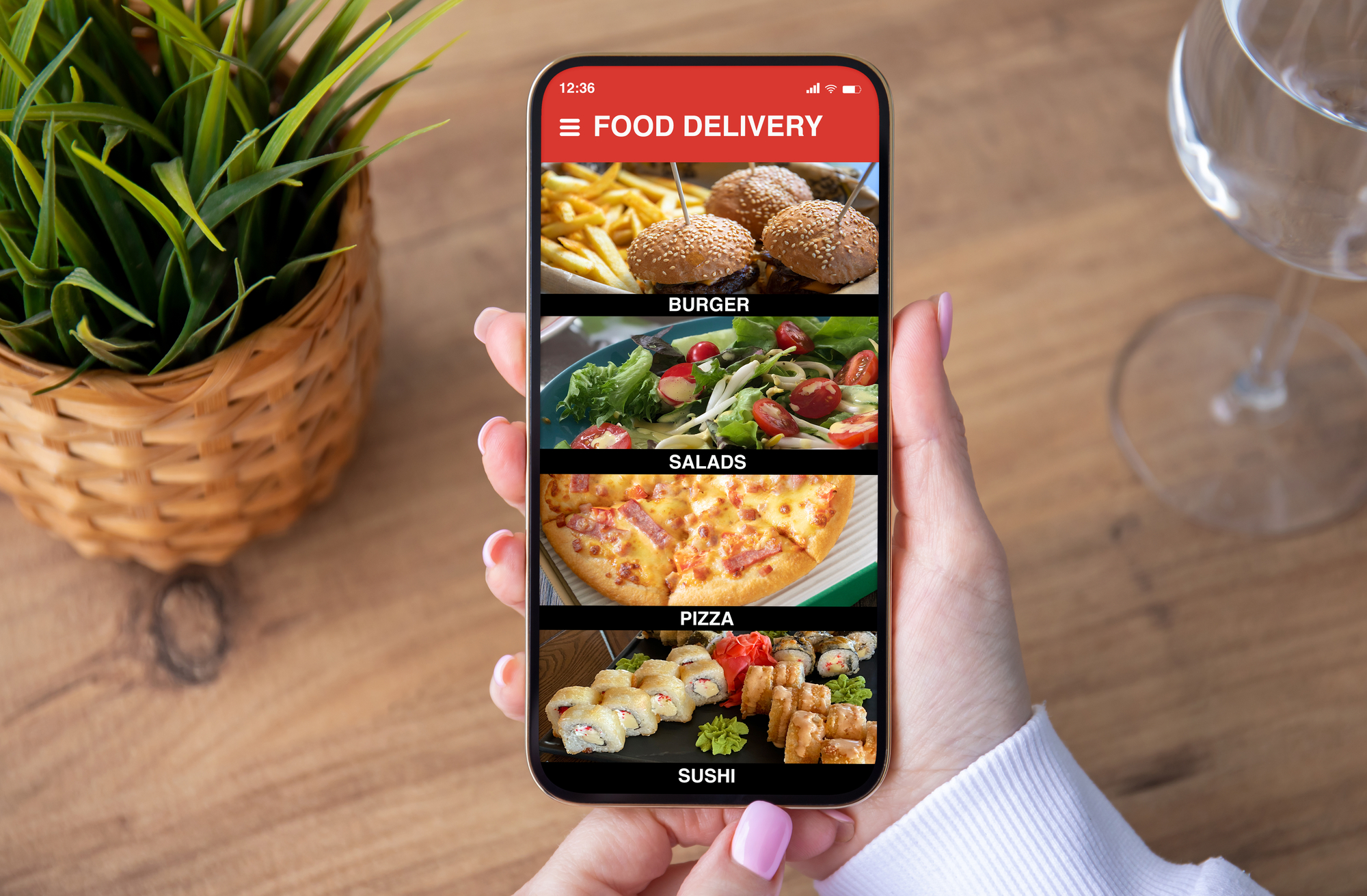 Una donna tiene tra le mani uno smartphone con aperta un'app di food delivery