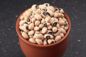 Fagioli dall'occhio nero in una ciotola alta di terracotta su una superficie scura