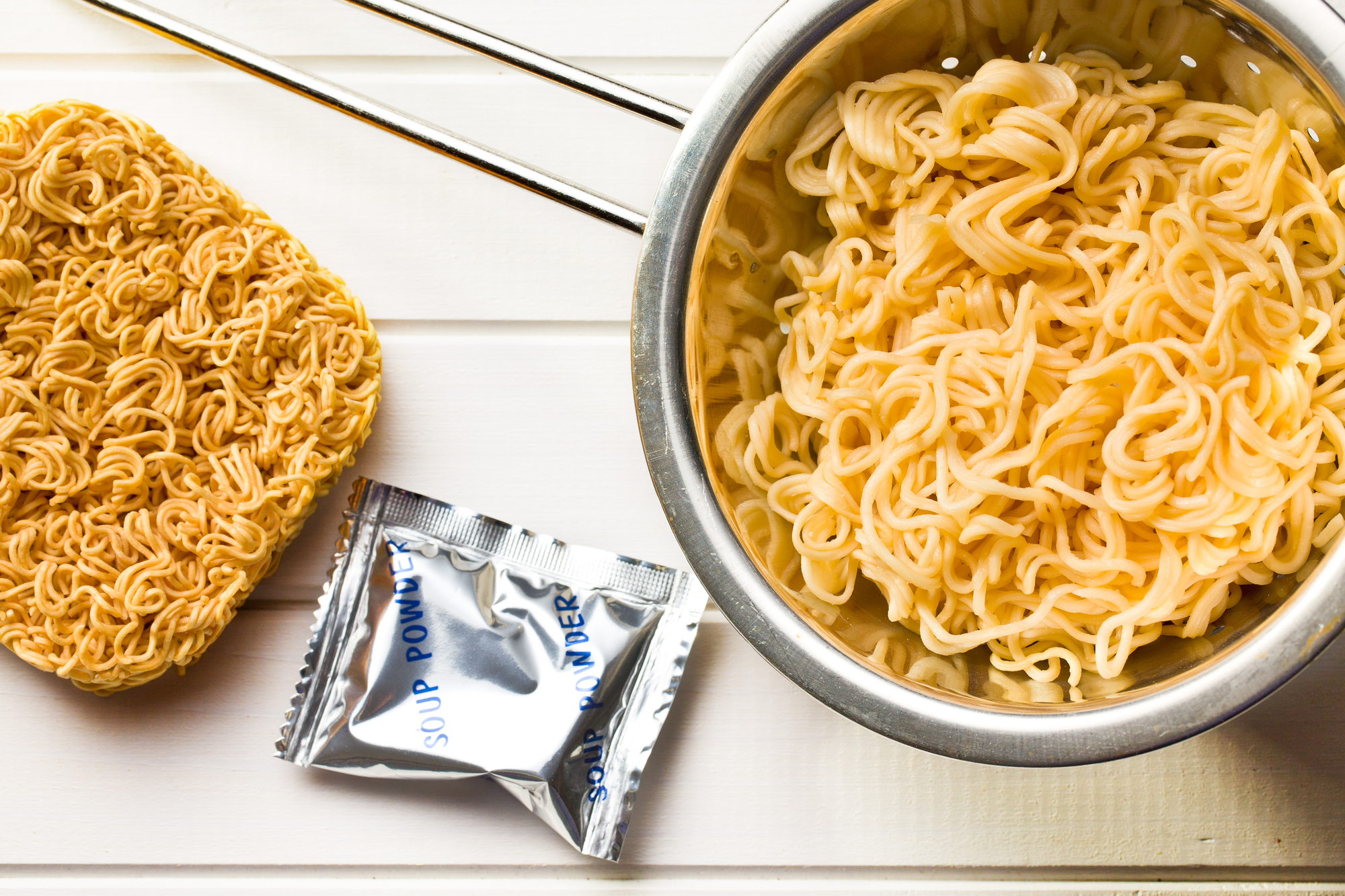 vista dall'alto di spaghetti cinesi secchi e bolliti su un tavolo di legno bianco