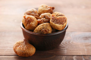 Fichi secchi in una ciotola su un tavolo di legno