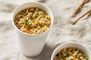 Due tazze di carta con noodles istantanei in brodo; concept: ramen