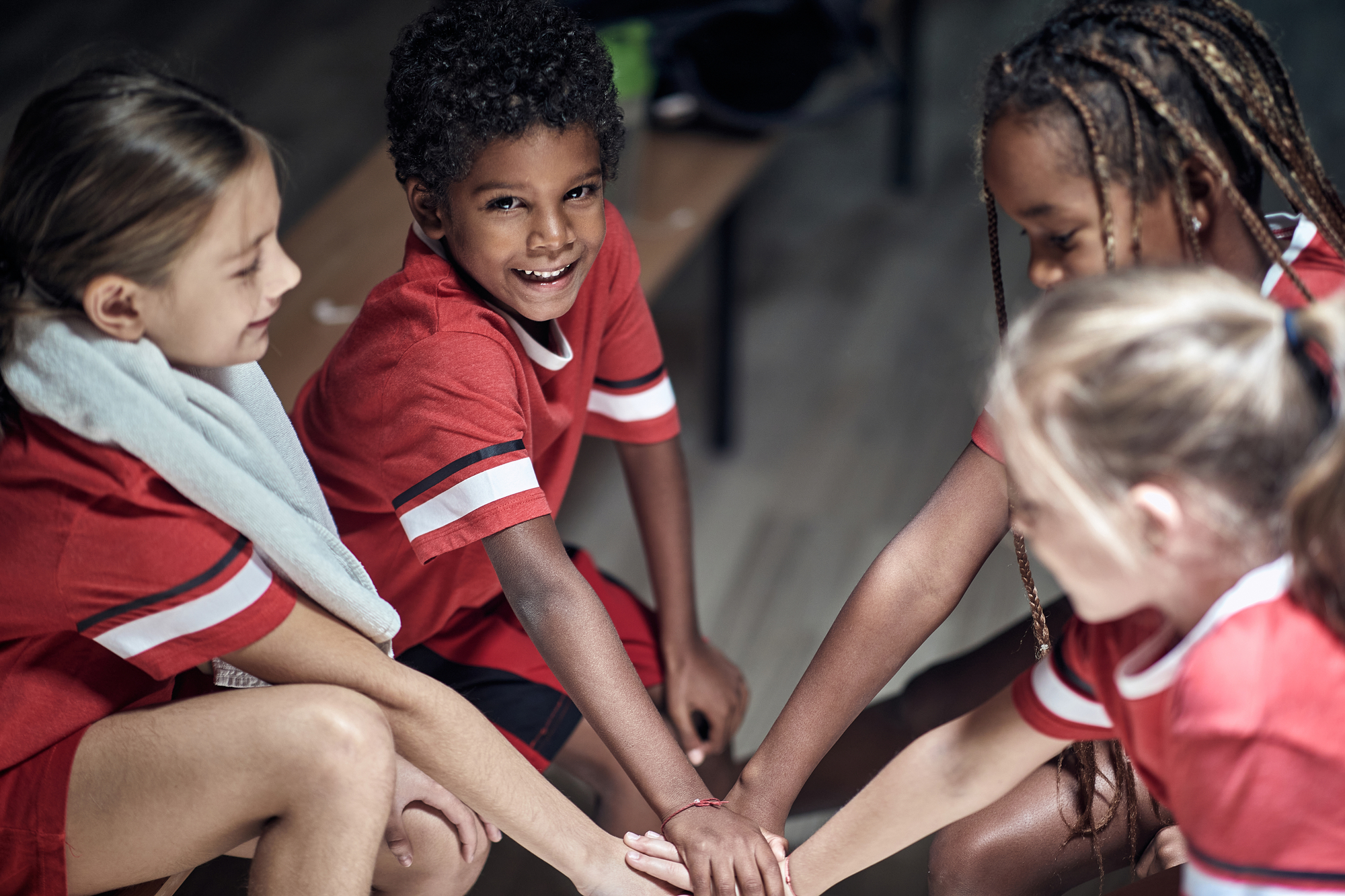 Ragazzi e ragazze felici che si danno il cinque prima della partita o dell'allenamento. sport sportivi movimento salute bambini ragazzi ginnastica