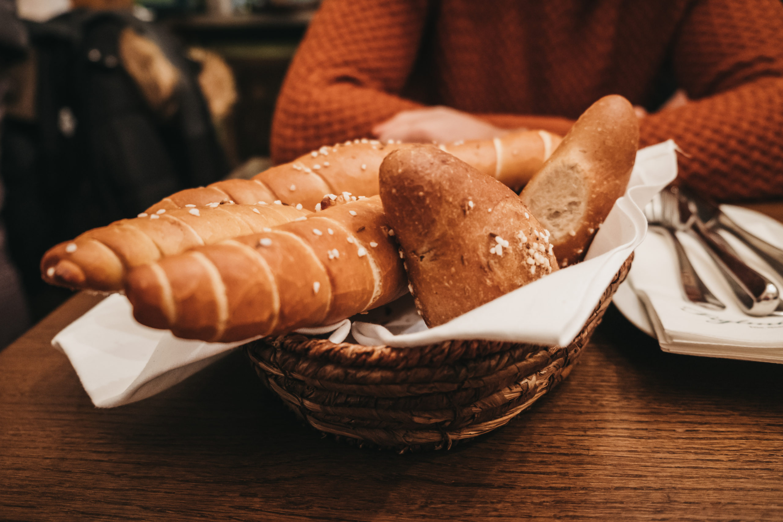 Cesto di pane sul tavolo di un ristorante davanti a una cliente