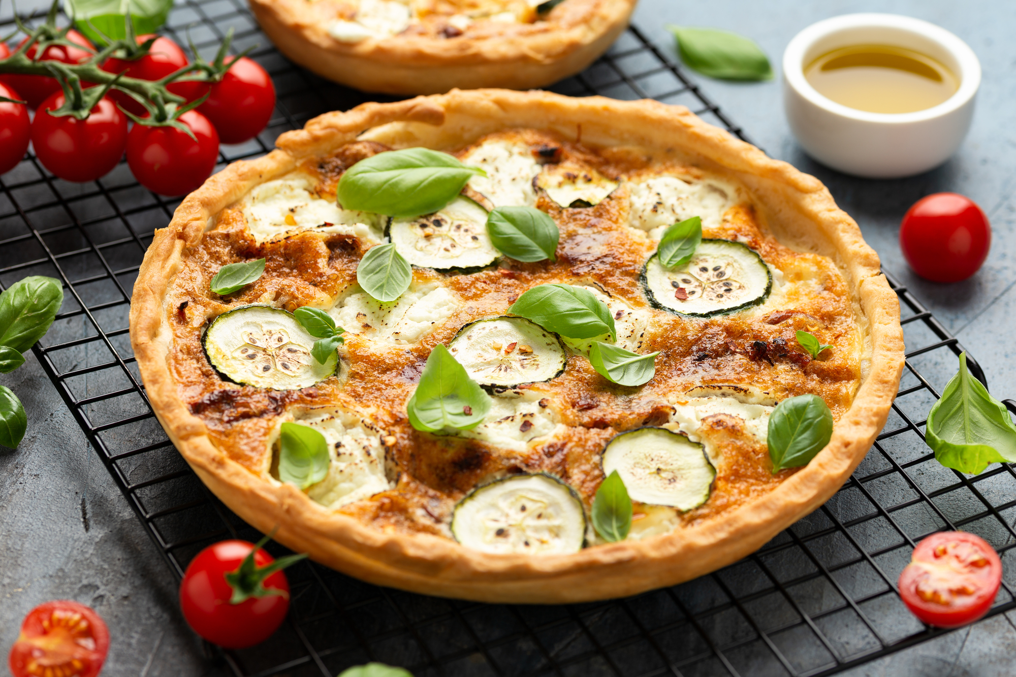 Quiche di pomodori al forno, formaggio di capra e zucchine servita in padella di ghisa con contorno di insalata. dieta vegetariana vegetali cucinare cotto forno